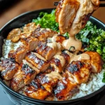 A colorful Thai Peanut Chicken Bowl with tender chicken, fresh vegetables, and creamy peanut sauce, garnished with peanuts and lime wedges.