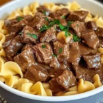 Crockpot Beef Tips and Noodles served in a white bowl with parsley